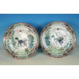 A pair of Chinese famille verte Plates, decorated dragons in a floral landscape, 9¾in diameter, A/F