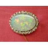 An Opal and Diamond Brooch claw-set oval opal, approx 32mm x 22m within frame of old-cut diamonds, e