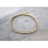 A Diamond Bracelet having round links each set brilliant-cut diamond in white and yellow gold stampe