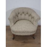 A Victorian Tub Chair by Howard & Sons with button back upholstery mounted upon turned walnut front