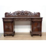 A 19th Century padouk Colonial pedestal Sideboard with pierced raised back, fitted three carved frie