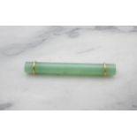 A Jade Bar Brooch set simple jade baton with yellow metal mounts, approx 56mm long