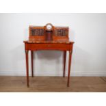 A late 19th Century ladies Writing Desk, the raised back with central inset clock flanked by brass g