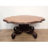 A Victorian style walnut Centre Table with shaped oval top on four pierced and scrolled supports