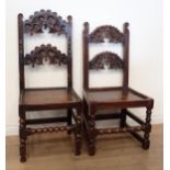 Two 17th Century and later oak Derbyshire Chairs with mask and scroll carved double back rails