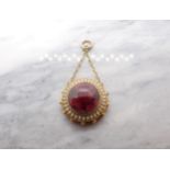 A Victorian Garnet and Enamel Pendant garnet cabochon within frame with white enamel. 25mm d.