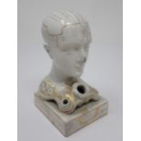 A Phrenology head Inkstand with ink and pen apertures on oblong base, the whole decorated gilt and d