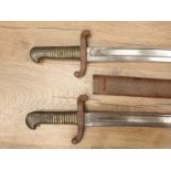 Two French brass handled Bayonets in metal scabbards