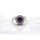 A Sapphire and Diamond Cluster Ring claw-set round sapphire within frame of eleven old-cut