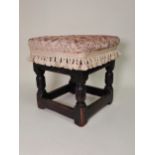 A Charles II, c.1680 joined oak Stool with later upholstered top above leafage carved arcaded