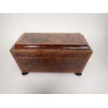 An early 19th Century burr yew Tea Caddy of sarcophagus shape with cross-banding and stringing,