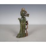 An Oriental carved jade standing figure of Chinese Lady wearing robes having branch and leaf applied