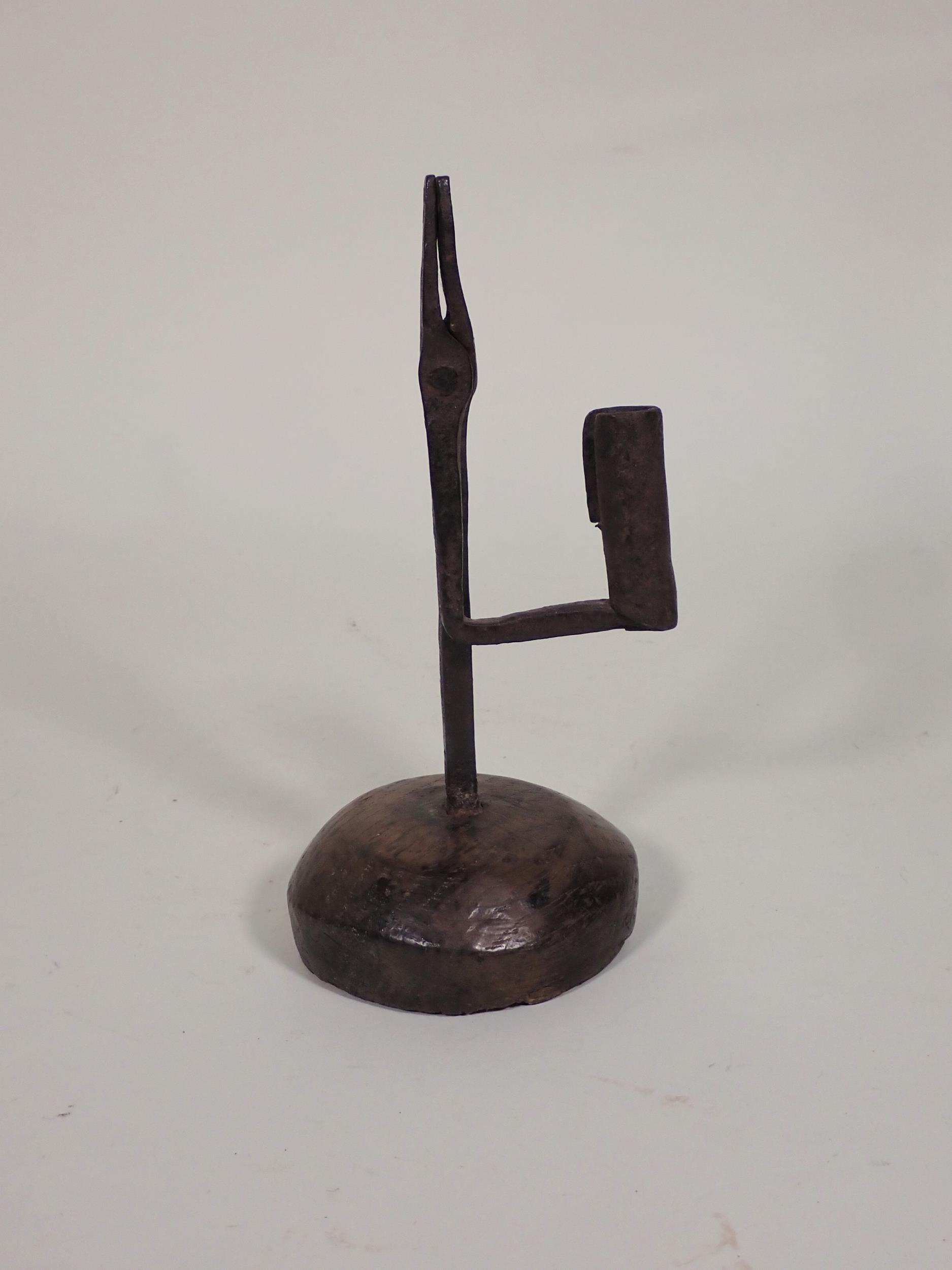 An 18th Century iron Rushlight Holder on domed wooden base, 9in H