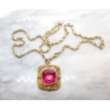 A synthetic Ruby Pendant in cannetille frame, Continental marks, on yellow metal chain