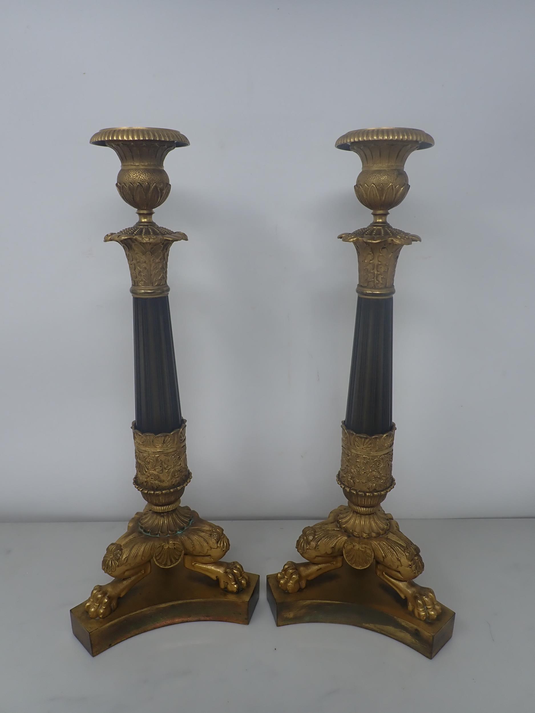 A pair of French Empire Candlesticks in ormolu and bronze, with classical mouldings, plain bronze