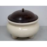A Chinese ceramic Pot with wooden cover and three peg supports, 8in diam.