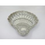 A Victorian silver scallop shape Dish with floral and scroll design raised on three shell feet,