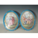 A pair of Continental oval Porcelain Panels depicting covers in landscapes with floral gilt borders,