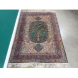 A fine quality Persian Rug with floral designs two the borders, and central oval depicting vase of