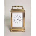 An antique French brass cased Carriage Clock with bevelled plate glass, stamped Made in Paris 5in
