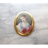 A Portrait Miniature Brooch with painted enamel of young girl in blue and pink dress in 18ct gold