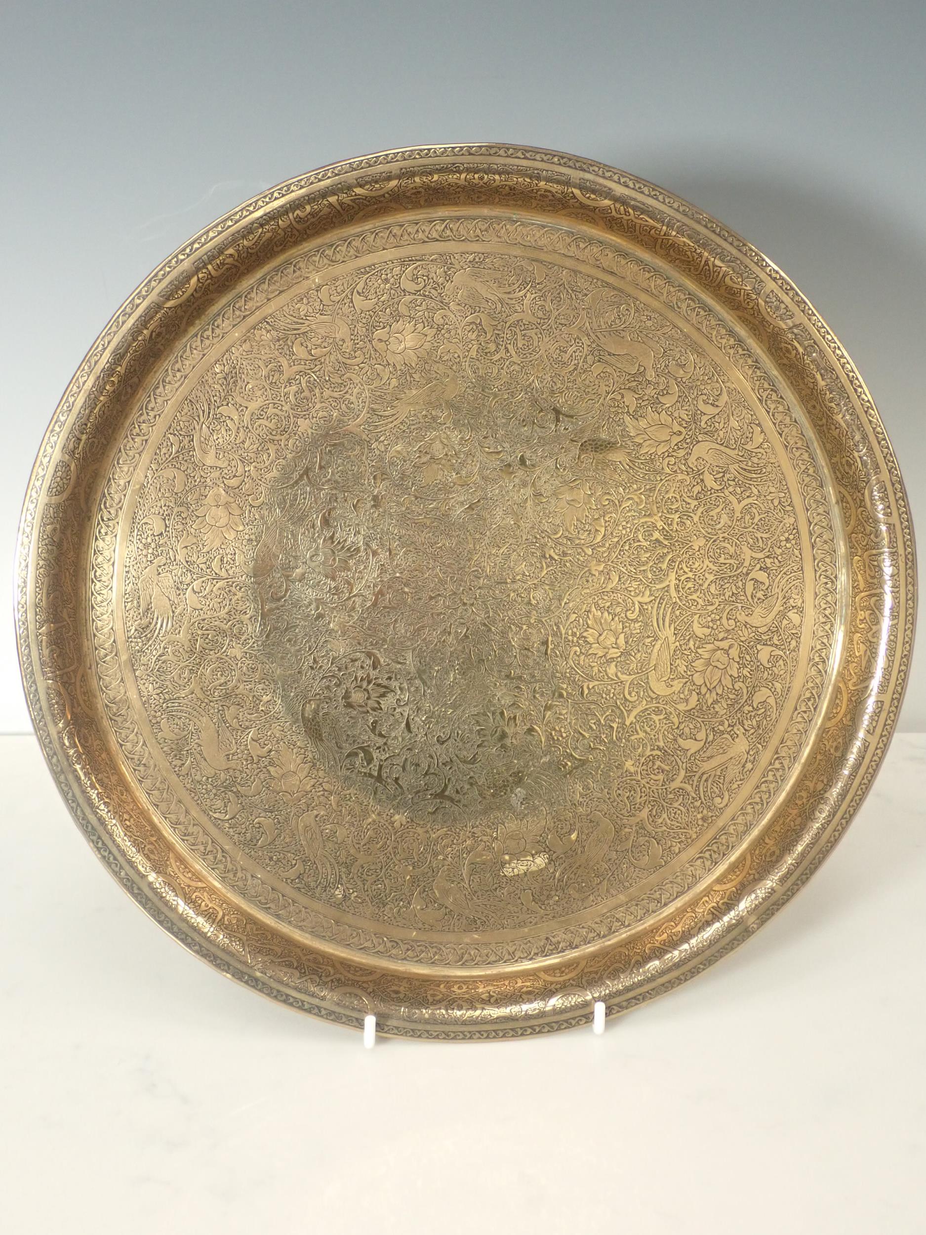 A Persian brass Tray with finely engraved design of exotic birds and flowers, bearing signature,