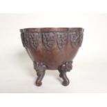 An Oriental bronze Jardiniere of lobed design, raised on four scrolled supports with dragon masks,
