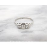 A Diamond three stone Ring millegrain-set graduated step-cut stones in platinum, ring size W