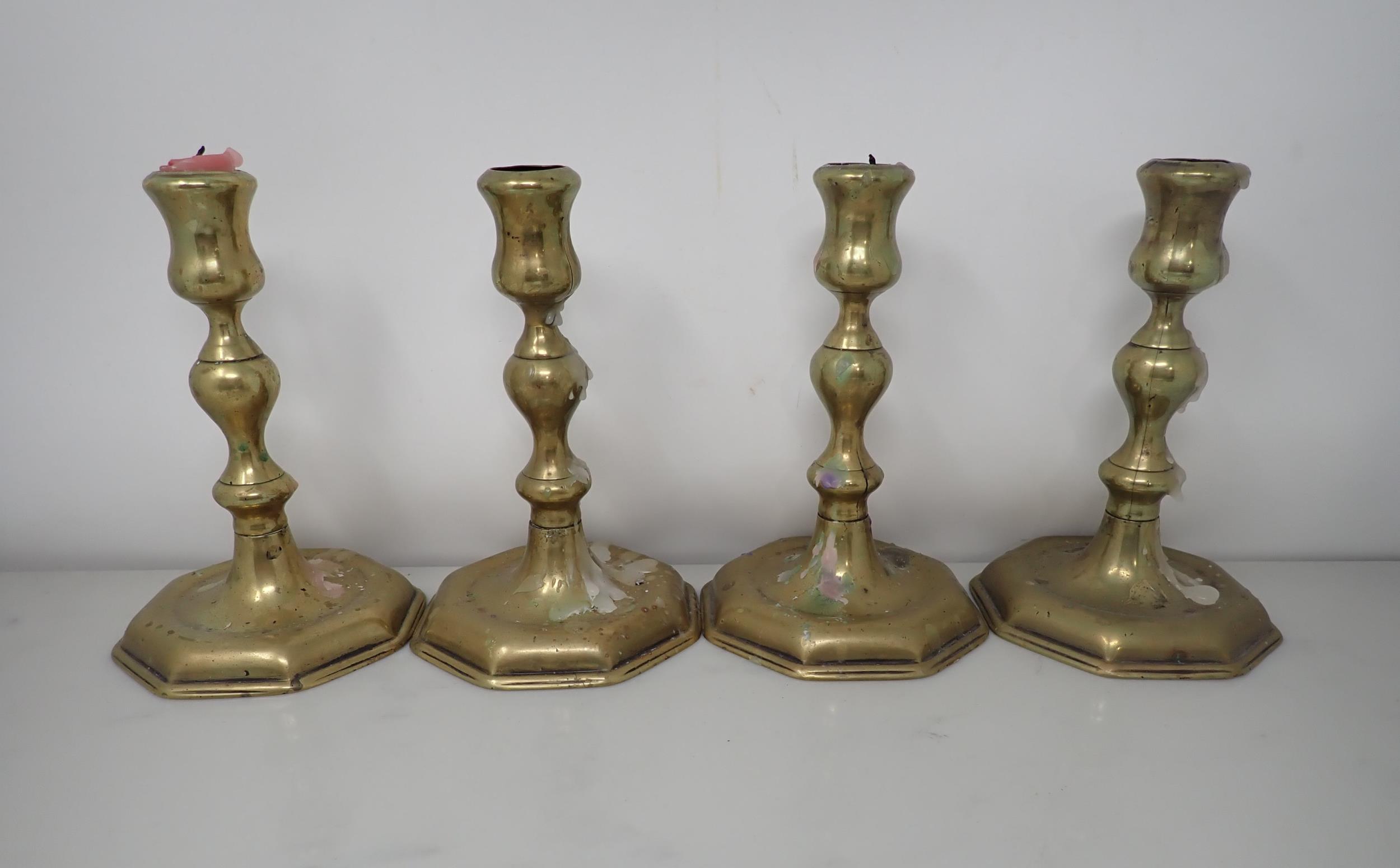 A set of four antique brass Candlesticks with baluster columns on octagonal bases, 6in