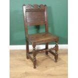 A 17th Century oak Hall Chair with pierced and carved top rail, panelled back and raised on