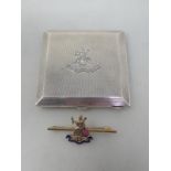 A 9ct gold and enamel Royal Norfolk Regiment Badge and a square silver Powder Compact with Royal