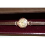 A vintage Ladies 9ct gold bodied watch with unusual hinged opening to the back