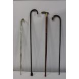 A selection of vintage walking sticks including a glass cane
