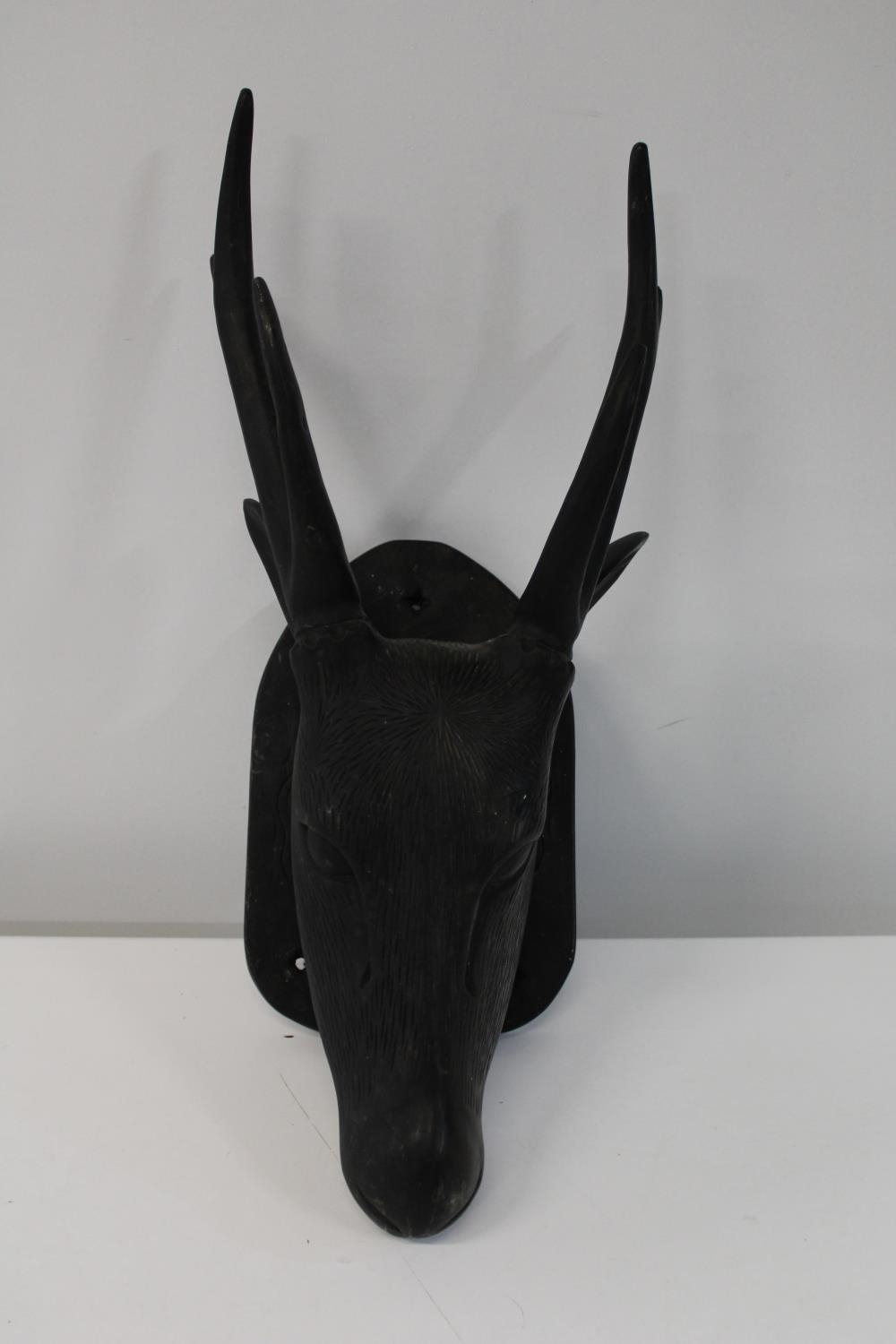An unusual hand carved & mounted wooden deers head 57cm tall