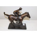 A bronze figure of a racehorse with jockey. 31cm x 26cm