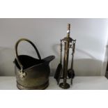 A vintage brass coal bucket and fireside tools