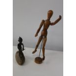A wooden articulated figure and unusual antique bronze figure mounted on a stone
