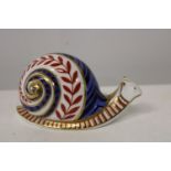 A Royal Crown Derby paper weight in the form of a snail with white stopper