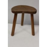 A vintage Robert 'Mouseman' Thompson of Kilburn milking stool with three legs and kidney shaped