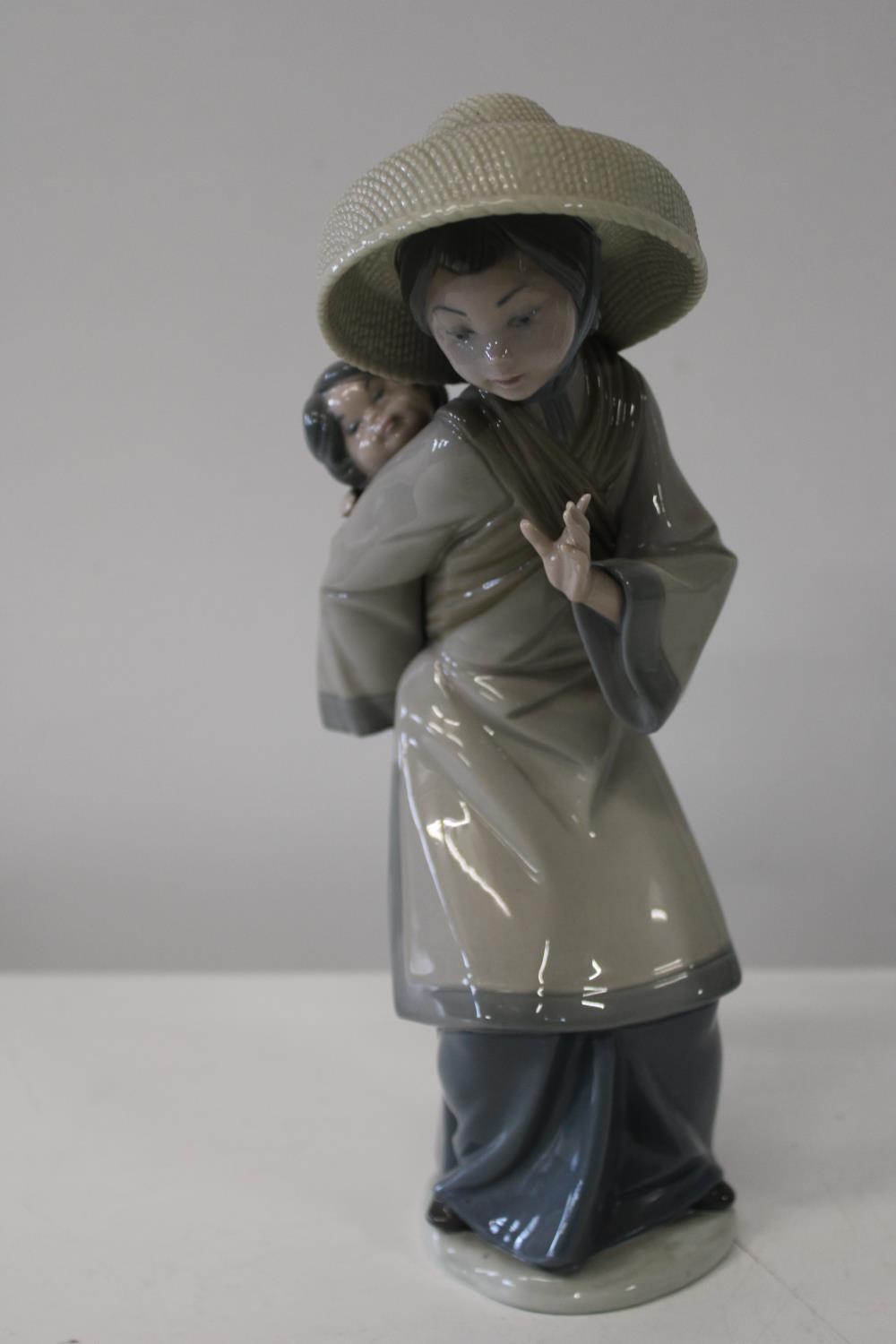 A Lladro figure in the form of a Chinese woman with child 27cm tall