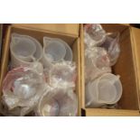 Two boxes of new plastic measuring jugs