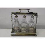 A good quality plated tantalus with three decanters and neck labels with key