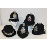 A selection of assorted Policeman's helmets