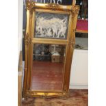 A gilt framed mirror with resin panel of cherubs above 118cm x 57cm. Collection only