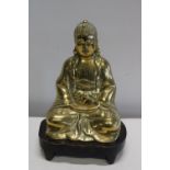 A hollow cast bronze Budha on a wooden stand 29 cm height.