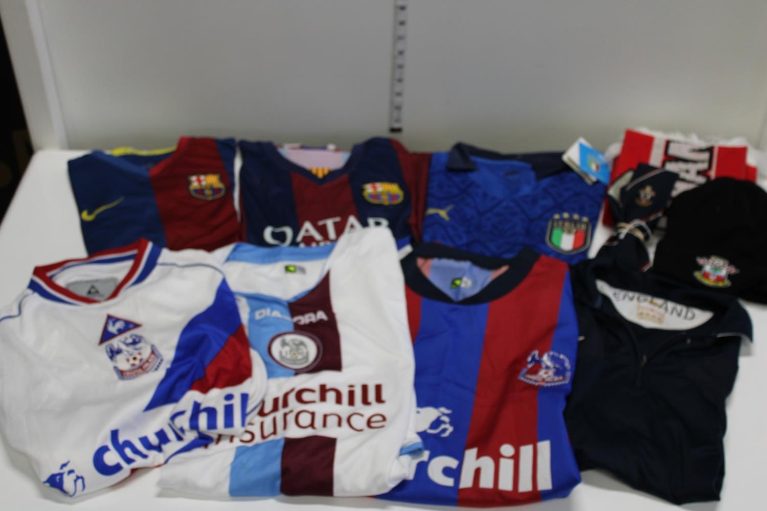 A job lot of football shirts & scarves etc (sold as seen no returns)