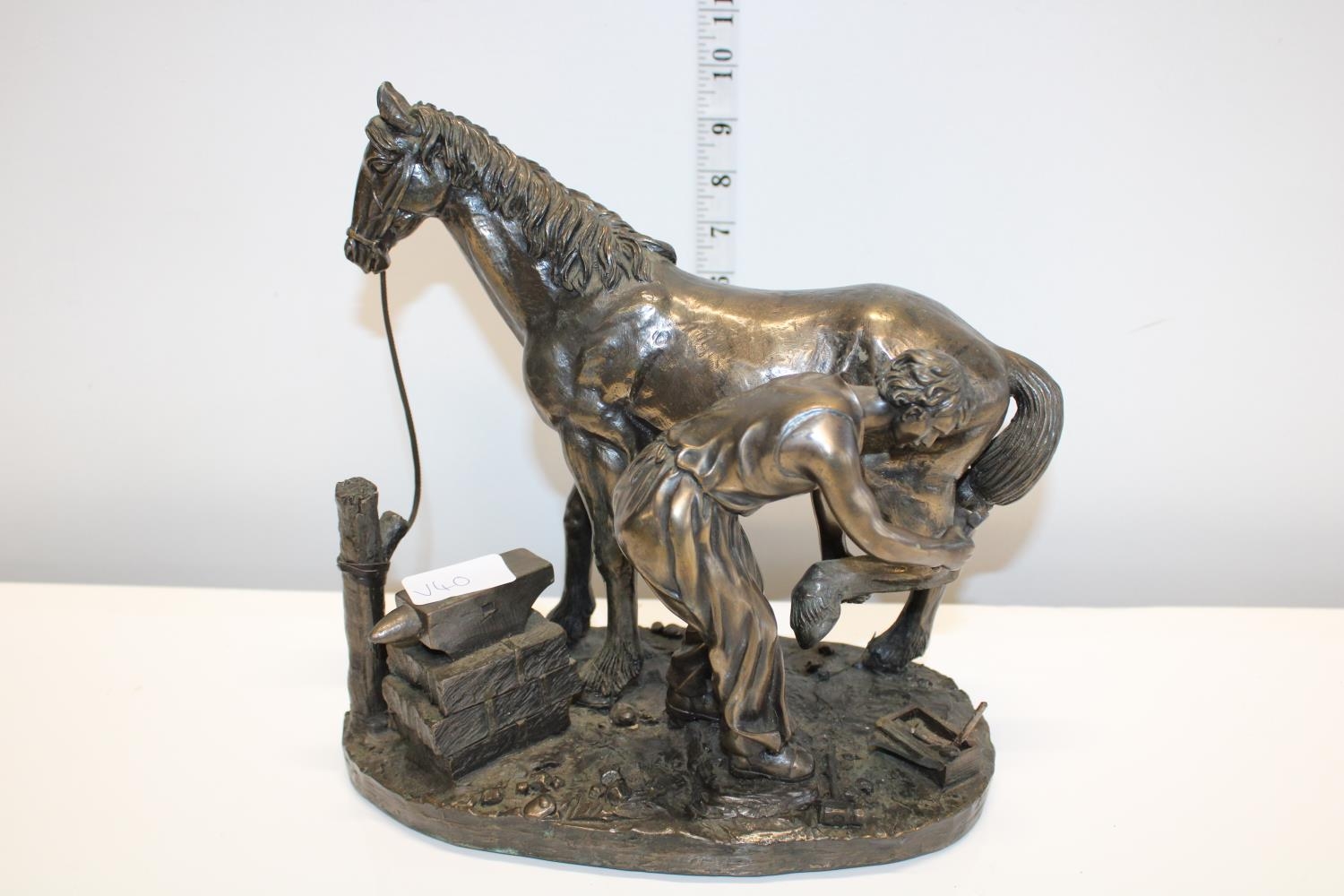 A vintage blacksmith & horse sculpture