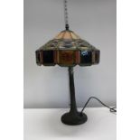 A Tiffany style table lamp on a metal base