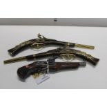 Three wall hanging flintlock pistols