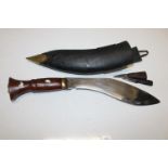 A wooden handled Kukri with inscription to blade. With sheath and smaller knives